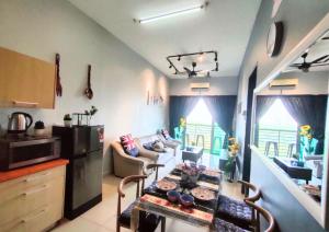 a kitchen and living room with a table in a room at Dpulze Comfy Homestay, 1-5 Pax - DP3 in Cyberjaya
