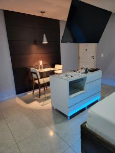 a kitchen with a stove and a dining room with a table at Status Motel Perimetral Adults Only in Olinda