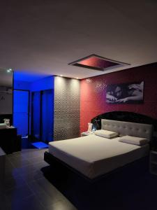 a bedroom with a large bed with blue lights at Status Motel Perimetral Adults Only in Olinda