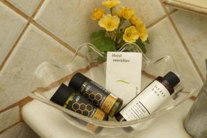 a glass container with cosmetics and flowers on a toilet at Nereids Guesthouse in Hydra