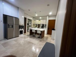 a large kitchen with a sink and a refrigerator at Lovely 2&3bedrooms condo klcc and kL tower view in Kuala Lumpur