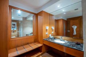 baño con lavabo y espejo grande en The Fern Surya Resort Kasauli Hills, Dharampur, en Kasauli