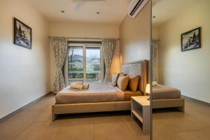 a bedroom with a bed and a window at SaffronStays Kaleidoscope, 4BR heated pool villa in Mulshi in Mulshi