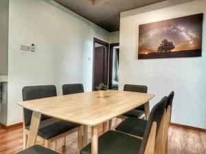 クチンにあるCozy Homestay Vivacity Megamallの木製のテーブルと椅子のあるダイニングルーム