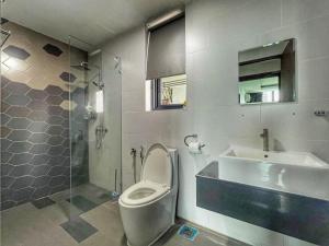 a bathroom with a toilet and a sink at Cozy Homestay Vivacity Megamall in Kuching