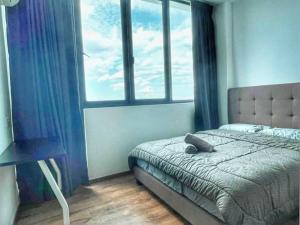 a bedroom with a bed and a large window at Cozy Homestay Vivacity Megamall in Kuching