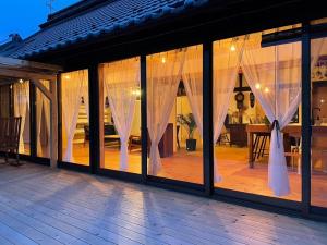 um quarto com grandes janelas com cortinas brancas em vintagehouse1925Bali - Vacation STAY 14502 em Nagano