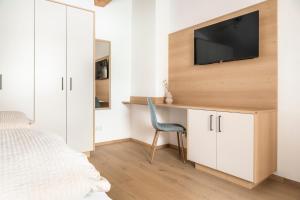 1 dormitorio con 1 cama y TV en la pared en Brennergut Ferienwohnung am Bauernhof, en Mühlbach am Hochkönig