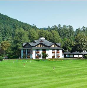 a large building in the middle of a grass field at Landhotel Naafs-Häuschen in Lohmar