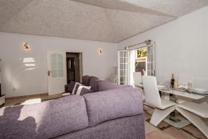 a living room with a purple couch and a table at Villa Vanesa luxury private villa with a heated pool, 4 bedrooms and 4 bathrooms in Adeje