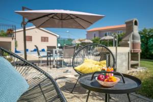 un bol de fruta en una mesa con sombrilla en Villa Giovanni Maria, en Vinež