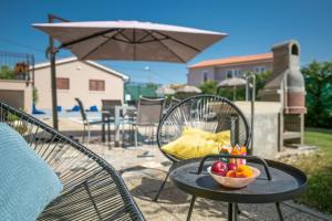 a bowl of fruit on a table with an umbrella at Villa Giovanni Maria by Briskva in Vinež