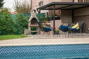 Vinež的住宿－Villa Giovanni Maria，一组椅子坐在游泳池旁