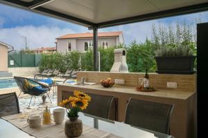 a patio with a table and an umbrella at Villa Giovanni Maria by Briskva in Vinež