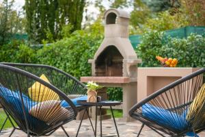 un patio con 2 sillas y una mesa con chimenea en Villa Giovanni Maria, en Vinež