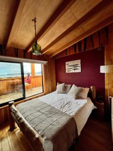 una camera con un letto e una grande finestra di Hotel Mitos a Quellón