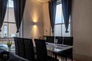 Lovely 3-Bed Apartment in Altrincham في ألترينتشام: غرفة طعام مع طاولة وكراسي ونافذة