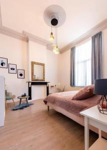 een slaapkamer met een bed, een bureau en een open haard bij House of Lara in Brussel