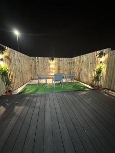 a patio with a table and chairs on a wooden deck at Immaculate 4-Bed detached House in Bootle in Bootle