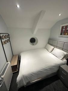 sypialnia z dużym białym łóżkiem i oknem w obiekcie Immaculate 4-Bed detached House in Bootle w mieście Bootle