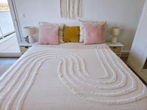 um quarto com uma cama grande e almofadas cor-de-rosa em Lakeside Provence - Appartement 4 étoiles face au lac de Monteux em Monteux