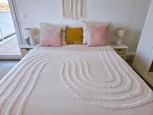 a bedroom with a large bed with pink pillows at Lakeside Provence - Appartement 4 étoiles face au lac de Monteux in Monteux