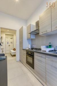 a kitchen with stainless steel cabinets and a stove at Sweet Stay Floriana Studios in Il-Furjana