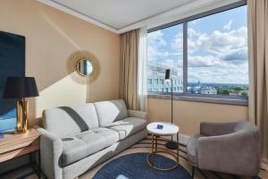 a living room with a couch and a large window at Radisson Blu Szczecin in Szczecin