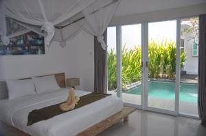 een teddybeer op een bed in een slaapkamer bij Chitra villa in Seminyak