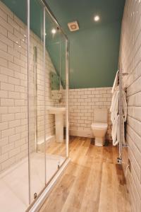 a bathroom with a glass shower and a toilet at The Old Success Inn in Sennen Cove +37 photos