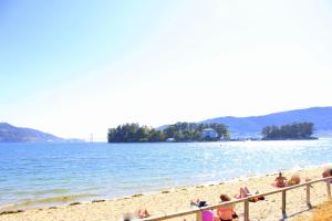 a group of people sitting on a beach at O Refuxio de la Jerezana in Redondela
