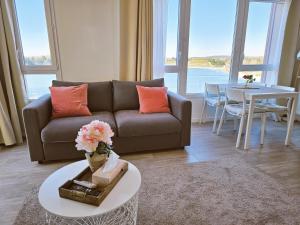 a living room with a couch and a table at Lakeside Provence - Appartement 4 étoiles face au lac de Monteux in Monteux