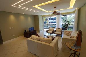 a large living room with couches and a tv at Condominio Agua Marinha, Praia Brava; 3 quartos, frente mar, in Florianópolis