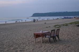 a table and chairs sitting on the beach at Kashinath Beach Huts in Agonda