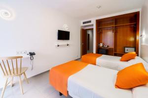 um quarto de hotel com duas camas e uma mesa e uma cadeira em Hotel Marina Resort em Benidorm