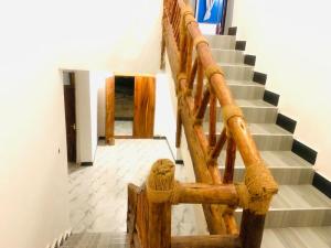 a stairway with a wooden railing and a stair case at Asili Nyumbani Residence in Kiwengwa