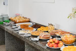 um buffet com muitos tipos diferentes de pão e pastelaria em Moriah Maceió Beach Hotel em Maceió