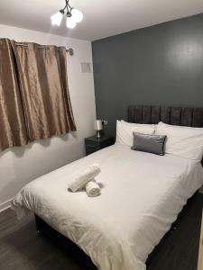 a bedroom with a white bed with a hat on it at Remarkable 2-Bed Apartment in Wolverhampton in Wolverhampton