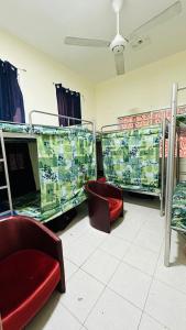 SUNSHINE BOYS HOSTEL في دبي: غرفة بسريرين بطابقين وكرسيين