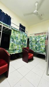 - une chambre avec 2 chaises et des lits superposés dans l'établissement SUNSHINE BOYS HOSTEL, à Dubaï