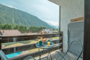 a table on a balcony with a view of a mountain at Les Marmottes d'Argentière - Happy Rentals in Chamonix-Mont-Blanc