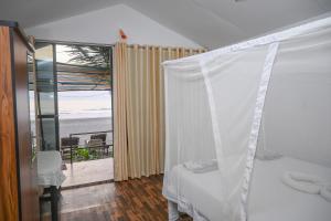 a bedroom with a bed and a view of the ocean at Kashinath Beach Huts in Agonda