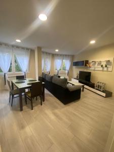 a living room with a table and a couch at La casa de las Flores in Ponferrada
