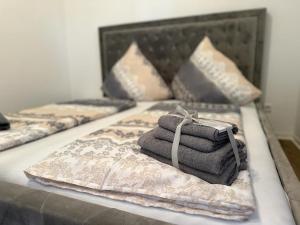 uma cama com duas camas com toalhas em Hotel Pension Matteo em Augsburg