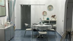 a white dining room with a table and chairs at Acquamarina in Agropoli