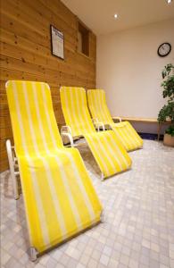 ナウダースにあるGasthof- Themen Frühstückspension Kristallの待合室の黄色い椅子3脚