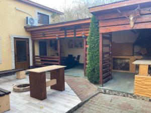 a patio with a wooden pavilion with a table at Casa Odihnei Villa & Tiny-House in Tîrnăveni