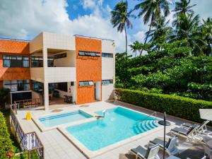 a swimming pool in front of a house at Moriah Maceió Beach Hotel in Maceió
