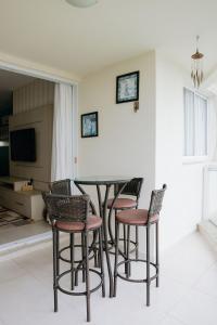 a dining room with a table and four chairs at Ap 3 quartos em home club - Beto Carrero/Penha in Penha