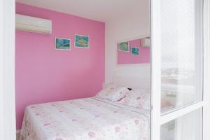 a bedroom with a pink wall and a bed at Ap 3 quartos em home club - Beto Carrero/Penha in Penha +31 photos